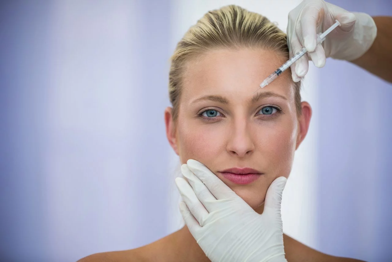 close-up of female patient receiving a botox injection on forehead